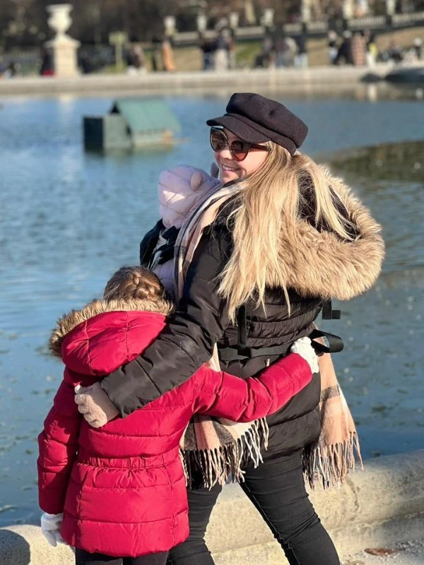 A mom standing with two kids on a family trip