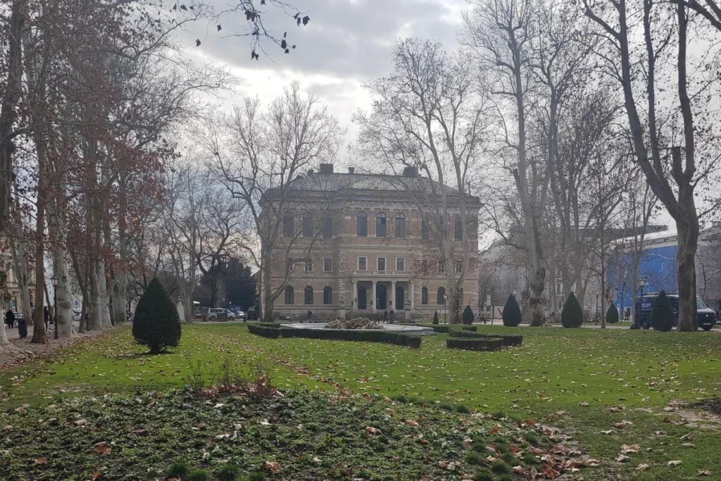 Zrinjevac Park in central Zagreb featuring the Croatian Academy of Sciences and Arts building and flat, stroller-friendly walking paths surrounded by tall plane trees.