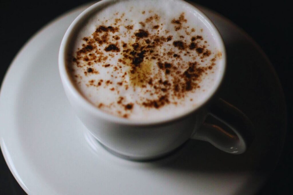 Bebiccino with cocoa dusting in a white ceramic cup on a saucer, a popular kids' drink in Zagreb cafes