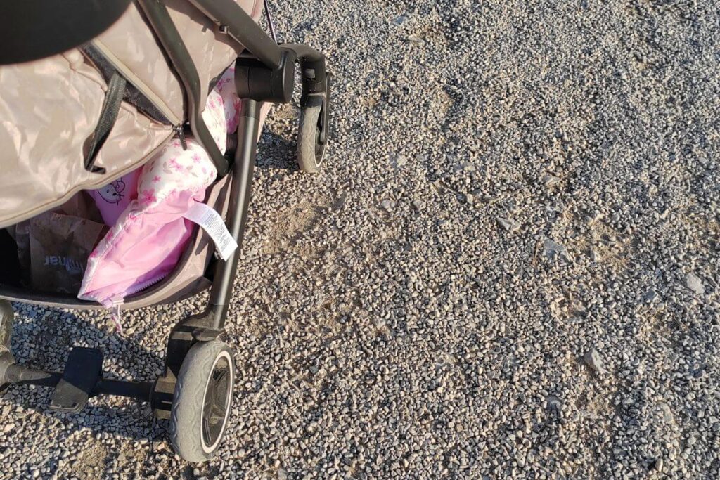 Close up of a pram's wheels on a grey gravel walking path in Maksimir Park.