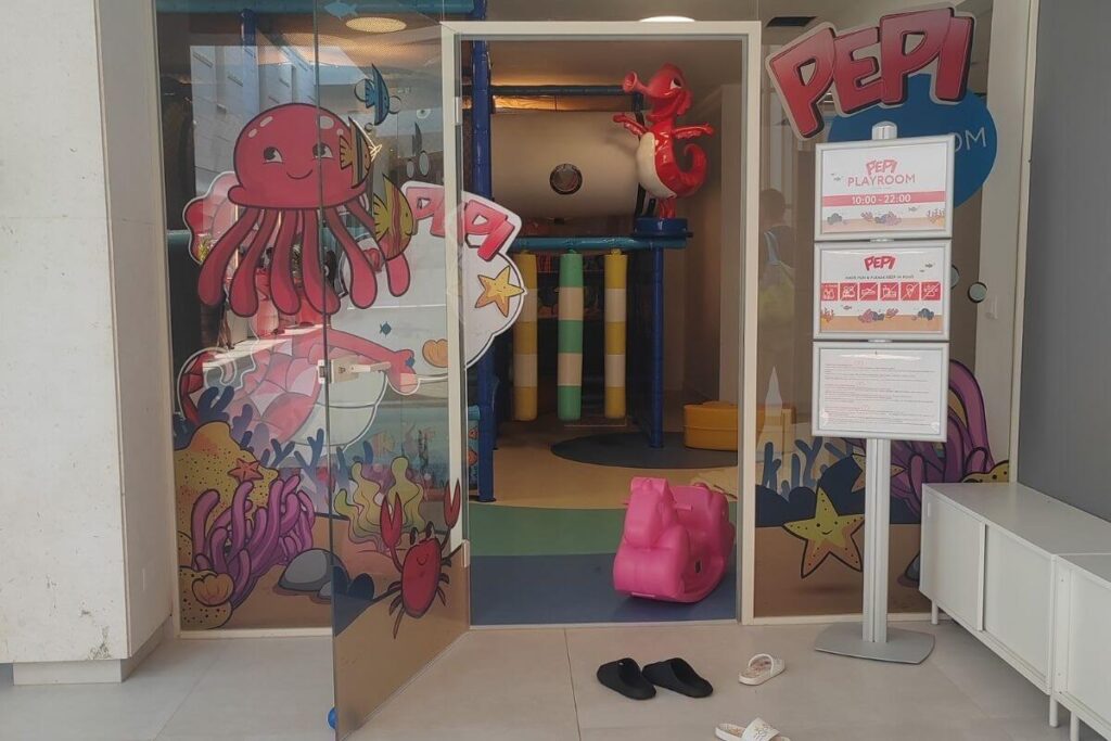 Entrance to the indoor Pepi Playroom at Hotel Garden Istra featuring colorful sea-themed decals and posted opening hours.
