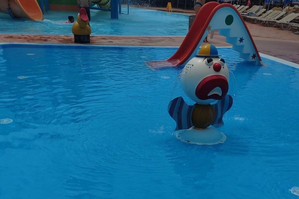 Shallow outdoor pool with a cute clown water sprayer and mini red slide for toddlers at Terme Tuhelj.