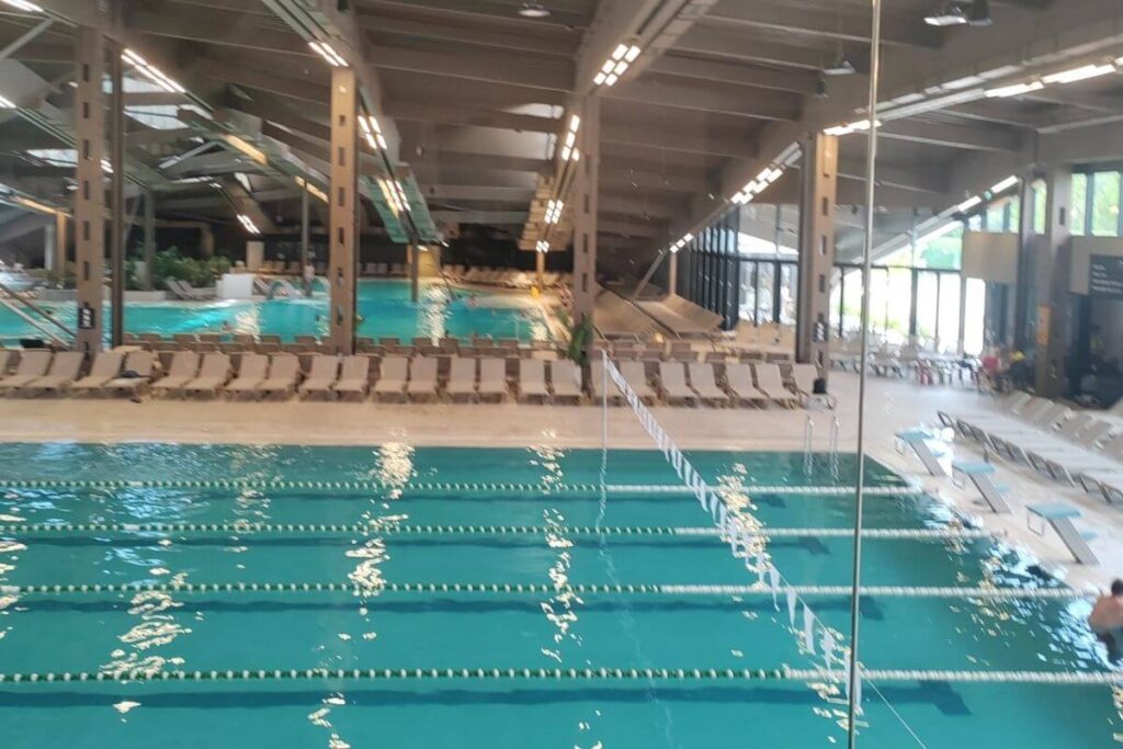 High-angle view of the large indoor swimming pool with lanes and comfortable loungers at Terme Tuhelj.