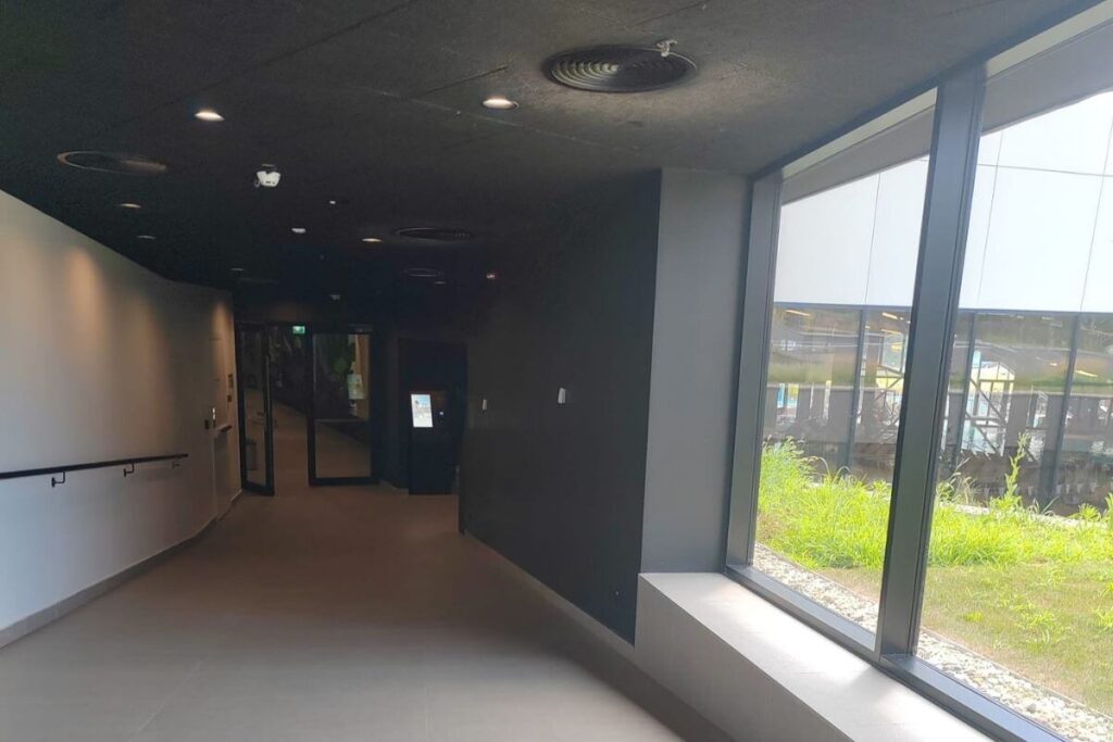 A wide, clean indoor hallway with large glass windows at Terme Tuhelj.