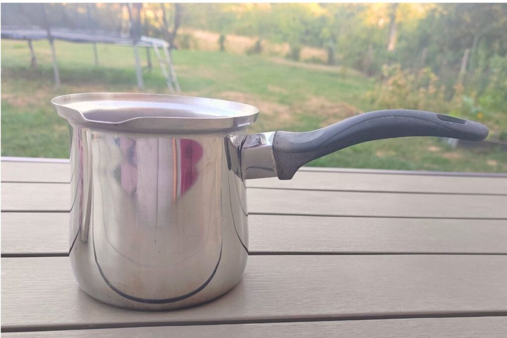 A stainless steel džezva coffee pot used for brewing traditional Turkish style coffee at home in Croatia